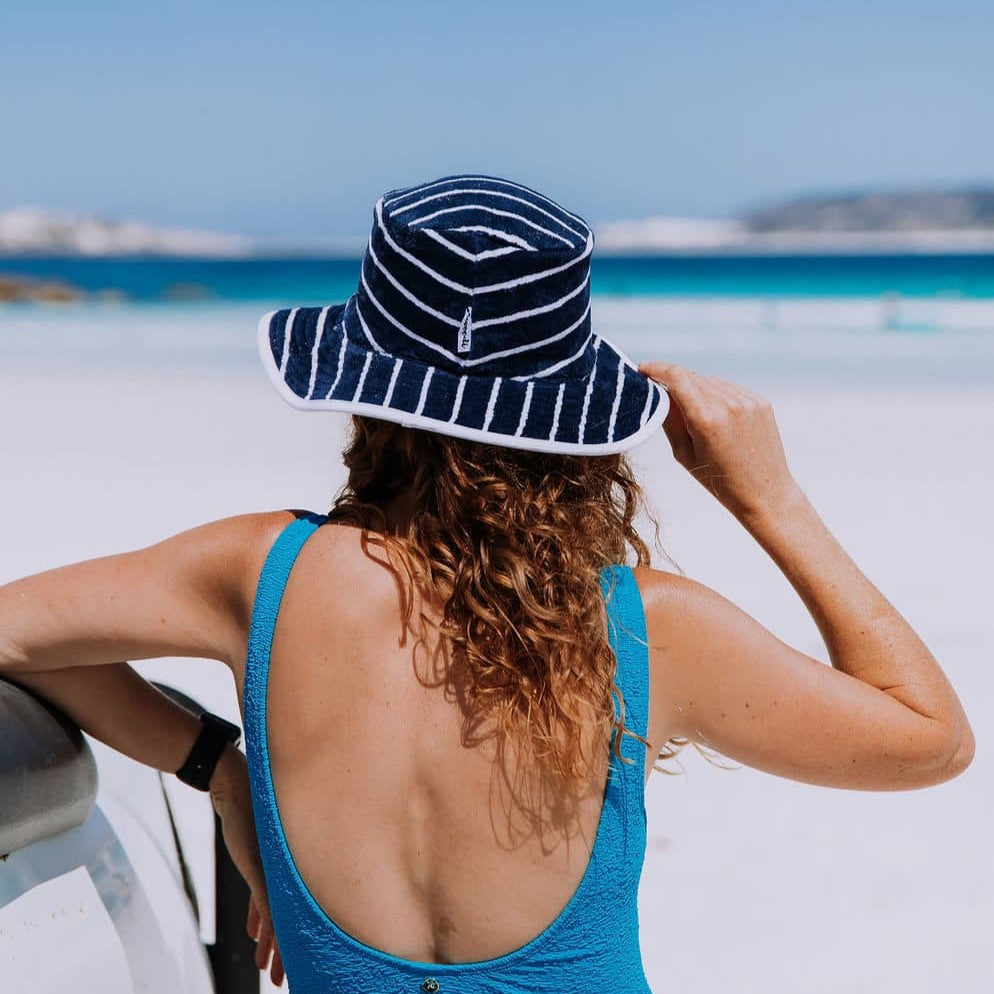 Back view of woman looking out to Wharton Beach wearing Swoodi sun protection wide brimmed hat