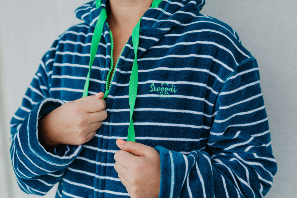 Close up of adult swim hoodie in turquoise stripe with green trim 