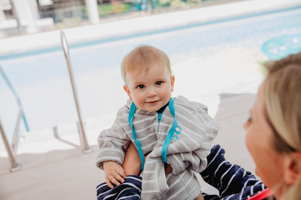 Baby wearing swim robe grey stripe with blue trim 