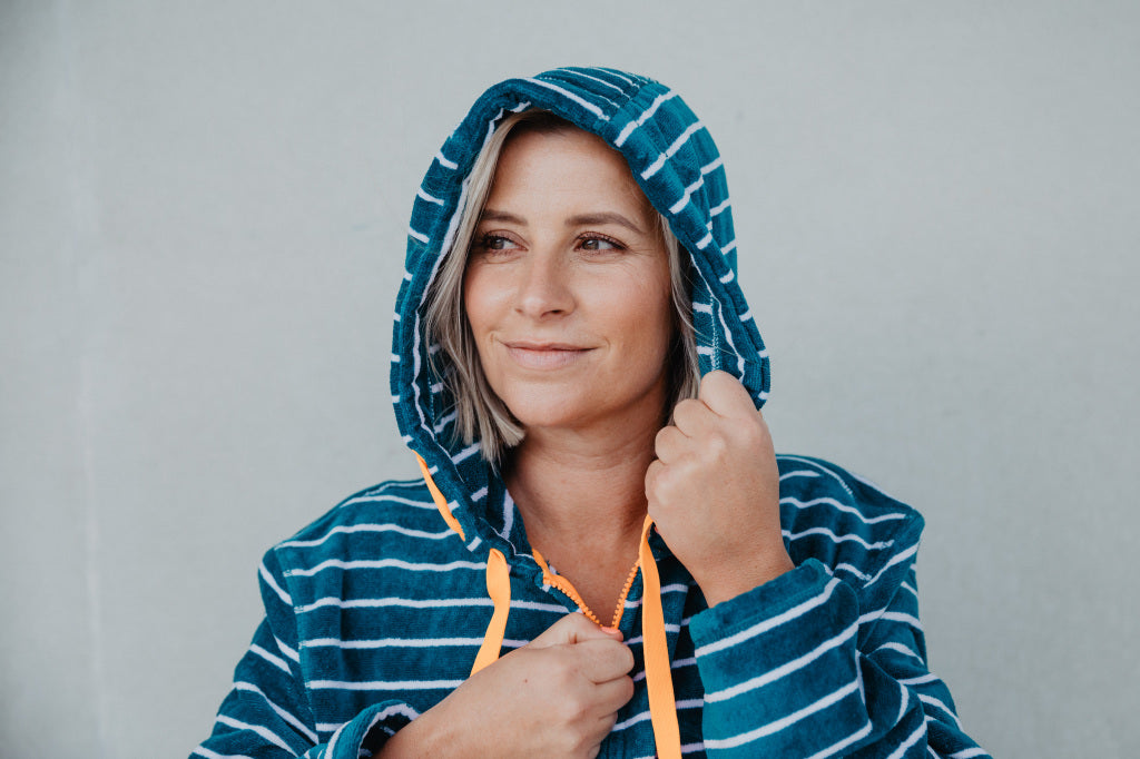 Close up of lady wearing turquoise with orange zip up hooded towel  