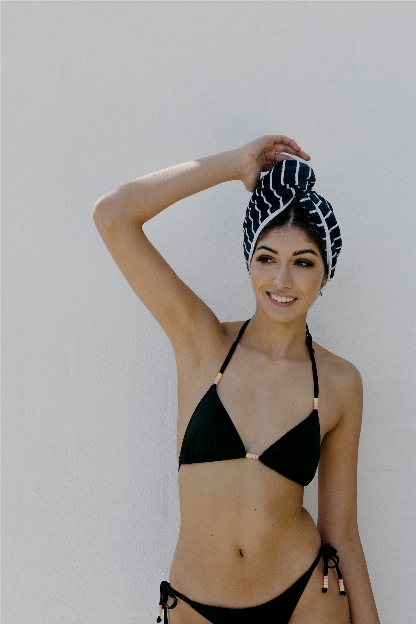 Female model front on wearing swoodi hair wrap in navy and white stripe and black bikini